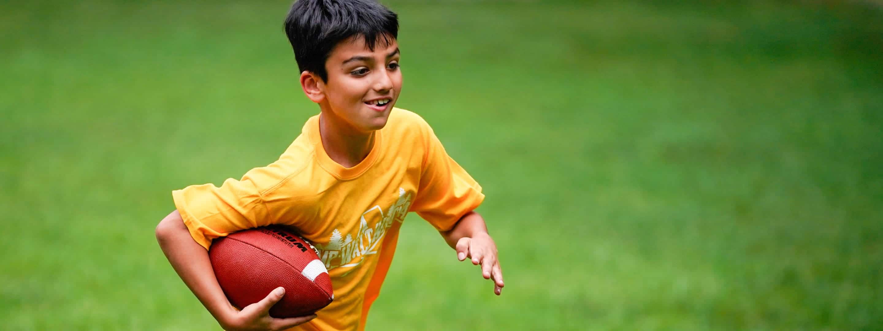 boy running with a football