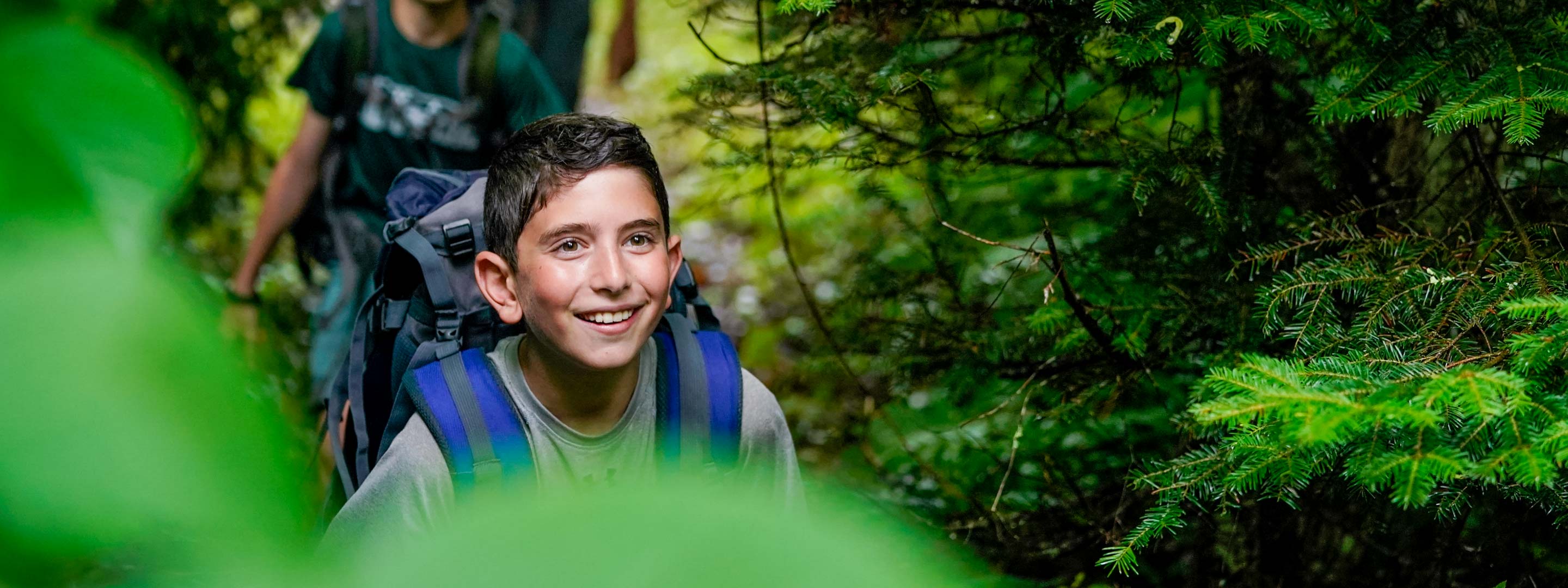 young boy walking through forest