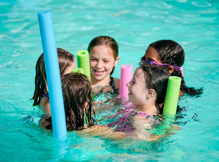 young girls in a pool with floaties