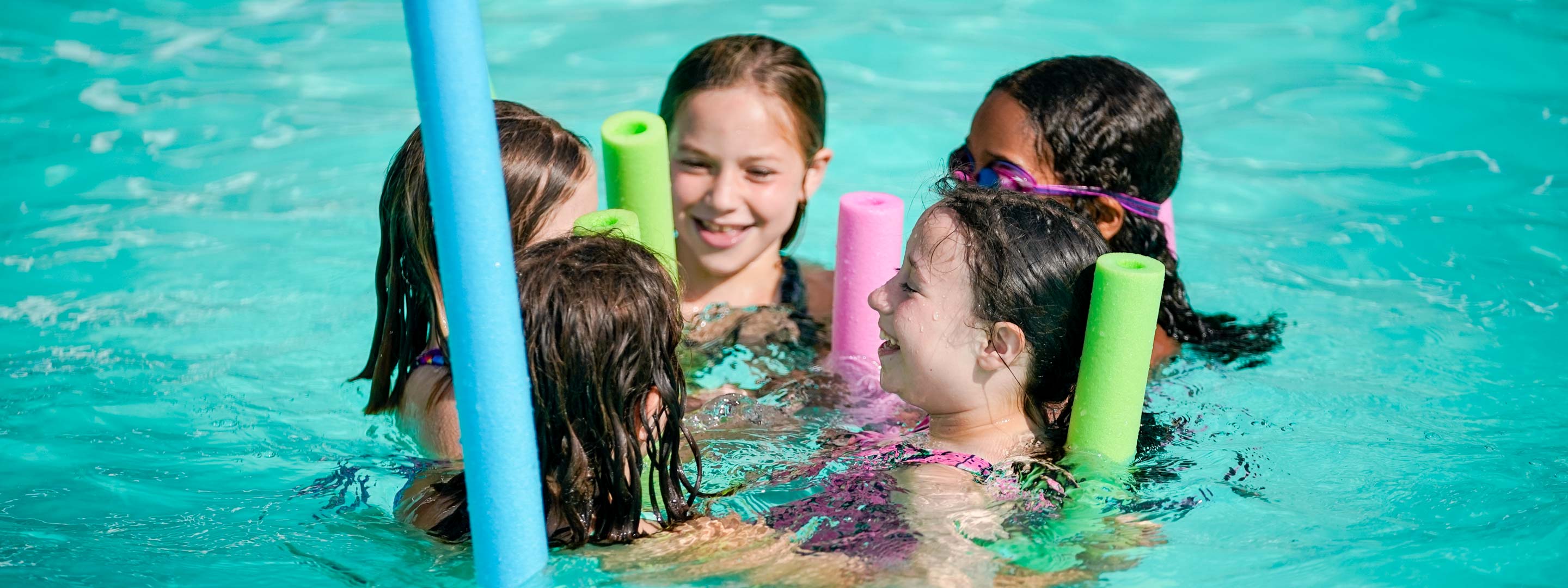 young girls in a pool with floaties