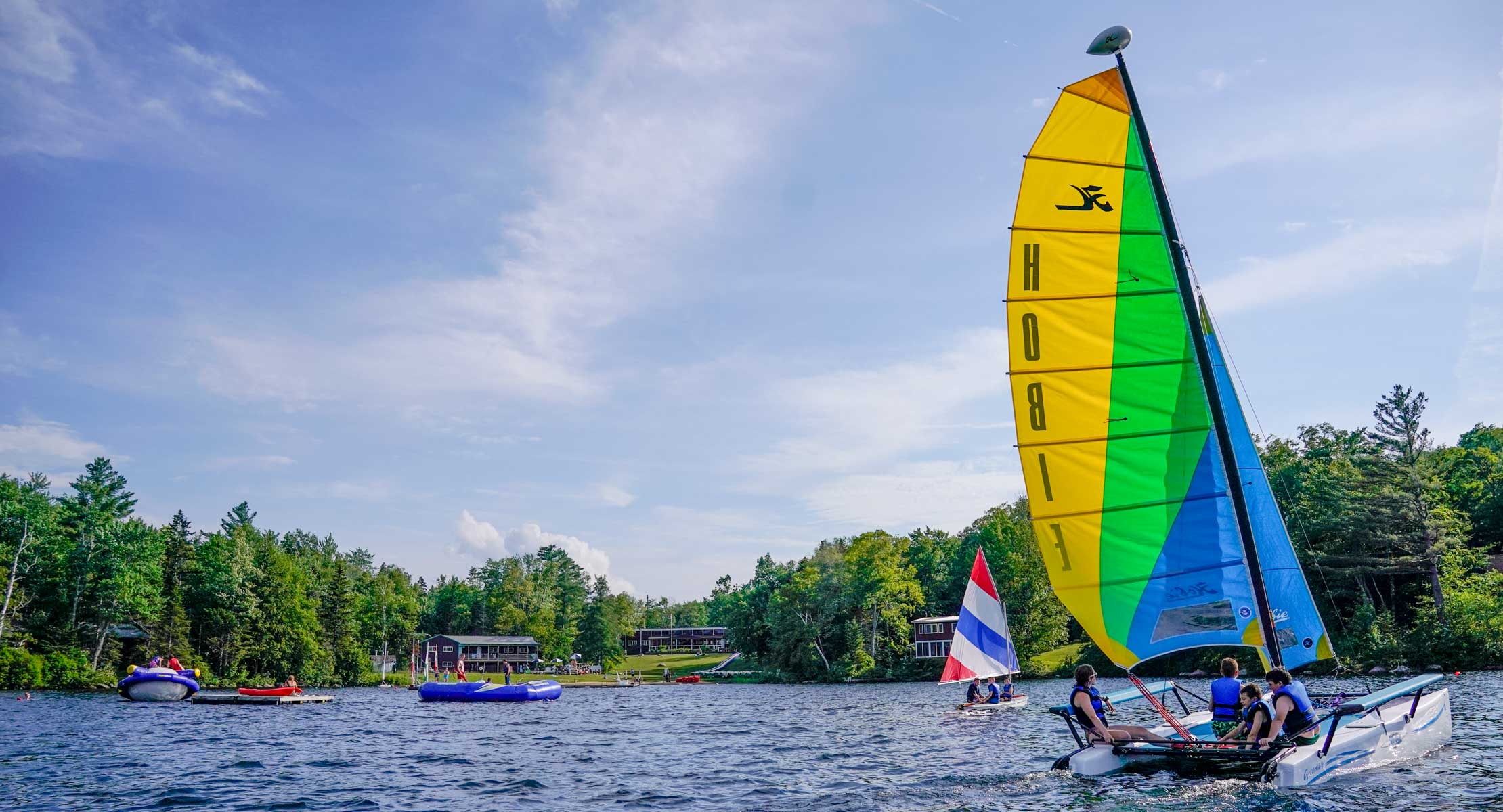 group of campers on a hobie cat boat on a lake