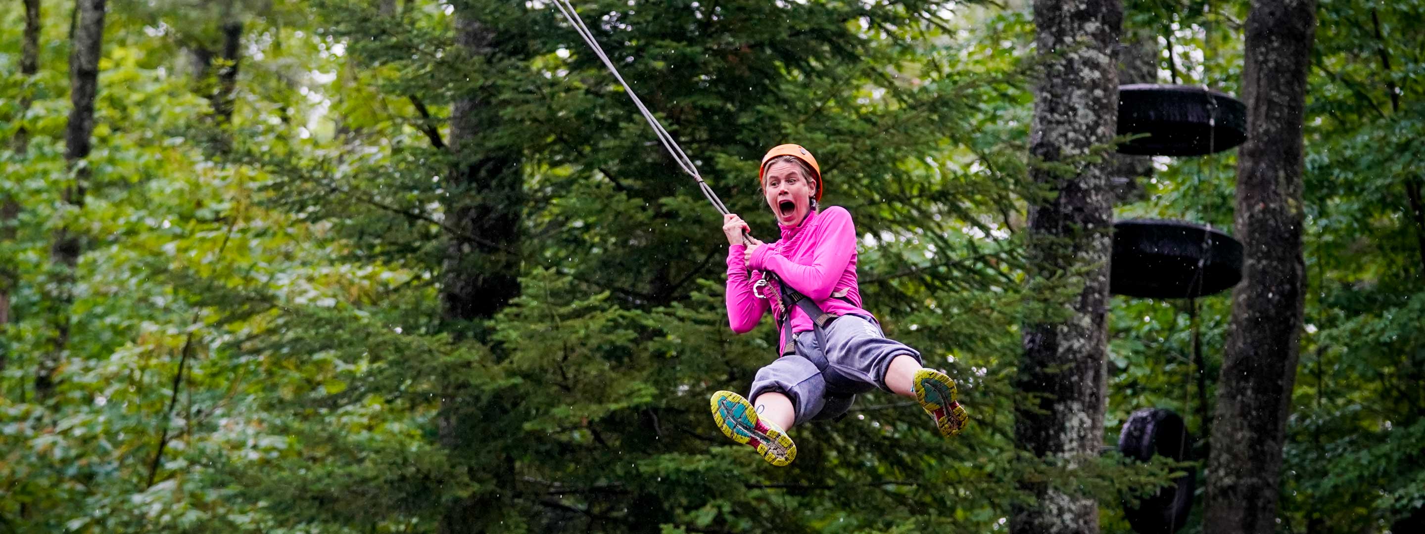 woman with a fearful look on her face on a zipline