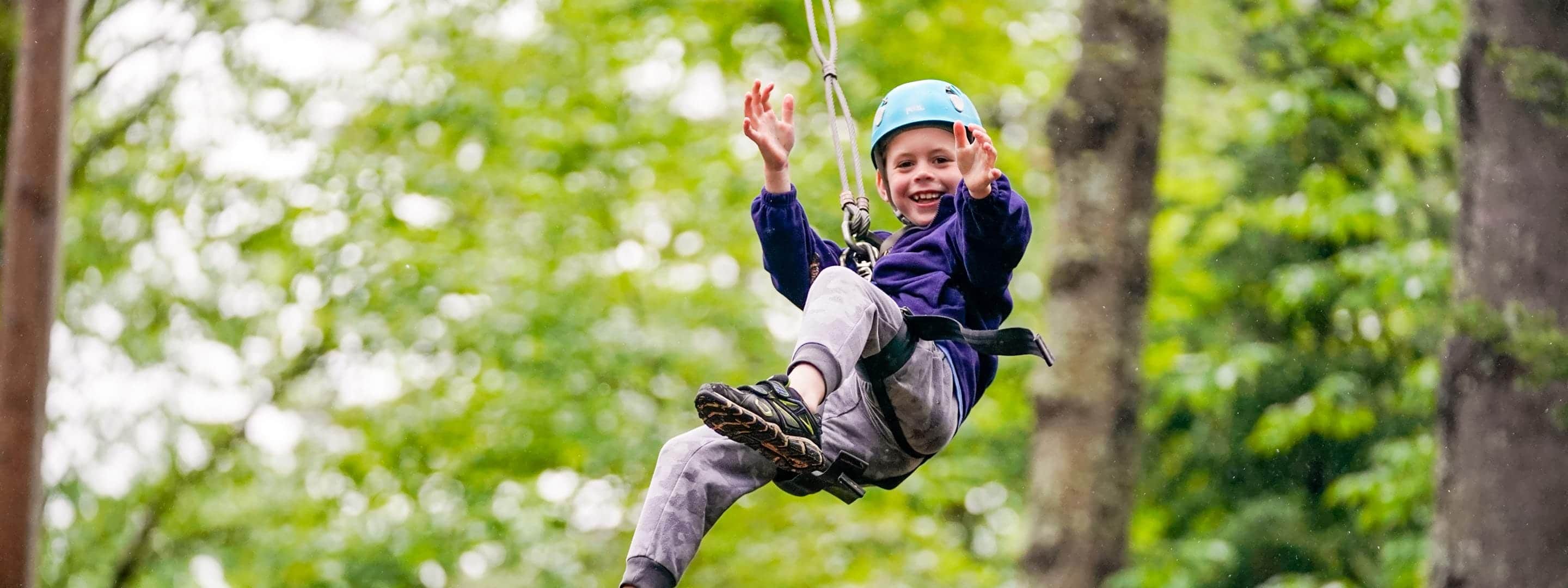 kid ziplining while smiling