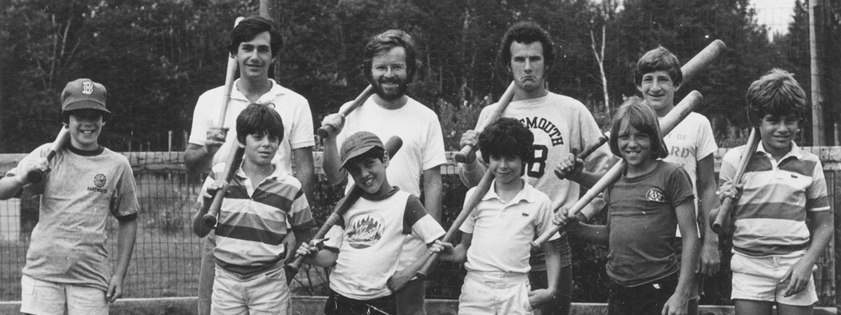 black and white picture of boy campers and counselors with baseball bats over their shoulders