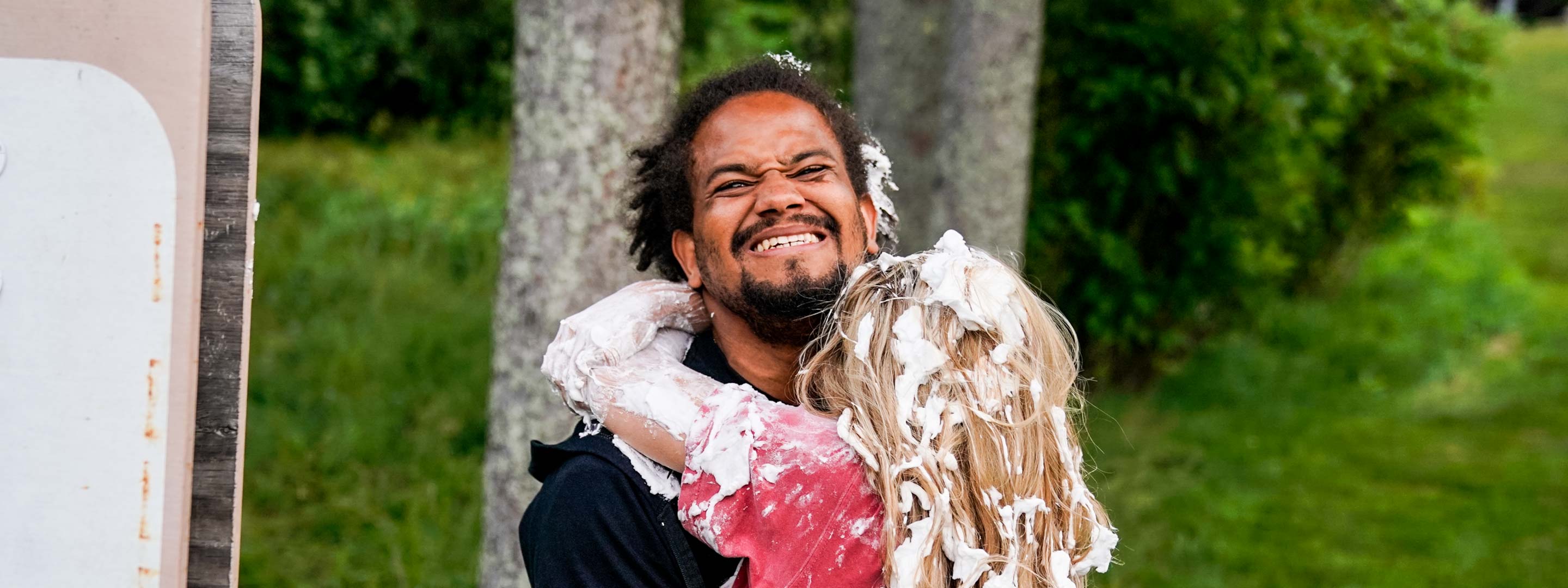 camper and counselor hugging with shaving cream on them