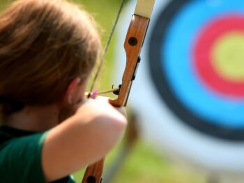 girl shooting an arrow at an archery target