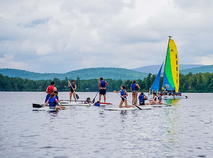 campers on paddle boats on the middle of a lake