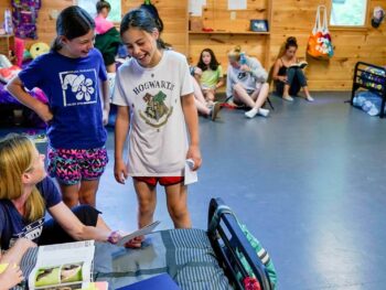 campers laughing with a counselor in a cabin