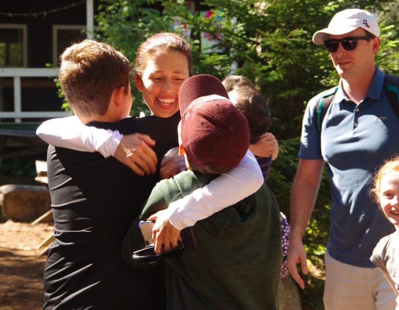 mom hugging her boys during visiting day at Camp Walt Whitman