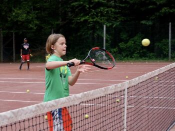 young camper playing tennis