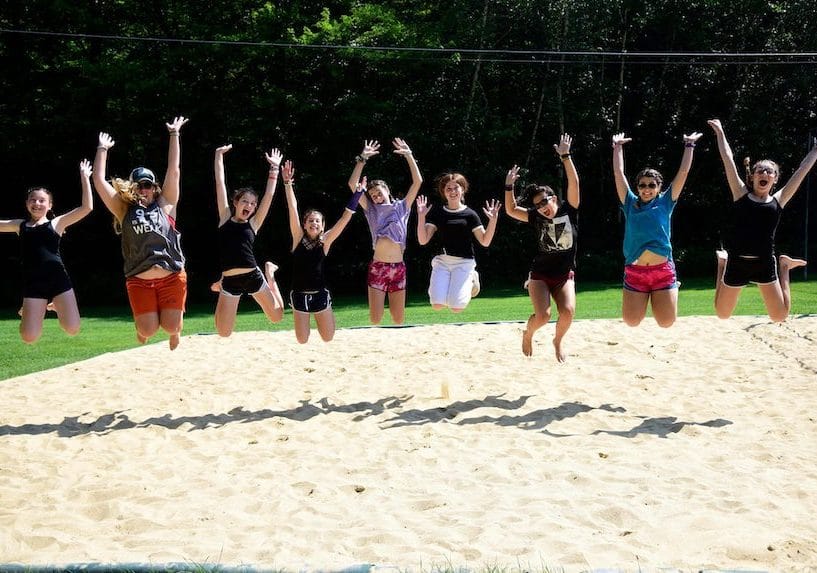 kids jumping in sand