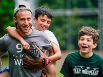 camp counselor with campers on baseball field